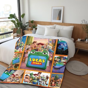 Op de afbeelding: Een pluche deken met een kleurrijke collage van Toy Story-personages en een centraal groen, kikker-vormig kader met de tekst Lucas Story in gele en rode letters, uitgestald over een wit bedsprei in een slaapkameromgeving.