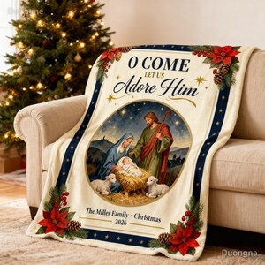 Könnte beinhalten: Eine cremefarbene Wohndecke mit einer zentralen kreisförmigen Illustration der Krippenszene mit Maria, Josef und dem Jesuskind. Der Text lautet O COME LET US ADORE HIM und The Miller Family Christmas 2026, umrahmt von Weihnachtssternen.