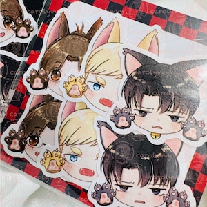 Puede incluir: Una colección de pegatinas con personajes de estilo anime con orejas de gato y manos en forma de pata. Las pegatinas tienen varios colores de pelo, incluyendo marrón, rubio y negro, con diferentes colores de ojos. Las pegatinas están sobre un fondo a cuadros rojo y negro.