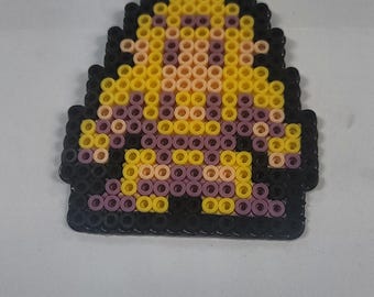 Puede incluir: Figura de pixel art en forma de escudo, creada con pequeñas cuentas de colores. El diseño presenta una cabeza amarilla, un cuerpo rosa y un contorno negro. La figura está sobre un fondo blanco.
