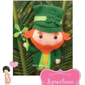 May include: A felt leprechaun doll wearing a green hat with a shamrock, green jacket, and orange beard. The doll is holding a green shamrock. The image includes the text "Leprechaun".