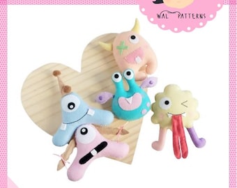 May include: Four felt monster toys in various colors and designs, including a blue monster with one eye, a pink monster with a toothy grin, a green monster with three eyes, and a yellow monster with a long tongue. The toys are arranged on a heart-shaped wooden surface. The text "AMAZING MONSTER" is at the top of the image, and the text "2024 by Wal Vieira" is at the bottom.