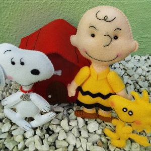 Op de afbeelding: Een set van drie pluche knuffels met personages uit de Peanuts-strip. De set bevat Snoopy, Charlie Brown en Woodstock. De knuffels zijn allemaal handgemaakt en hebben een charmante, vintage uitstraling.
