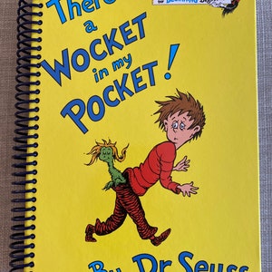 May include: A spiral-bound children's book with a bright yellow cover. The title "There's a Wocket in my Pocket!" is in blue, with an illustration of a boy and a whimsical creature. The author's name, Dr. Seuss, is at the bottom.