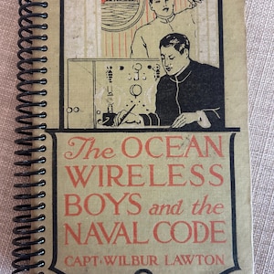 May include: A vintage book titled "The Ocean Wireless Boys and the Naval Code" by Capt. Wilbur Lawton. The cover features a black and white illustration of two men working on a radio.