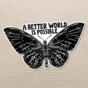 Puede incluir: Pegatina en blanco y negro de una mariposa con el texto "Un mundo mejor es posible" impreso en ella.