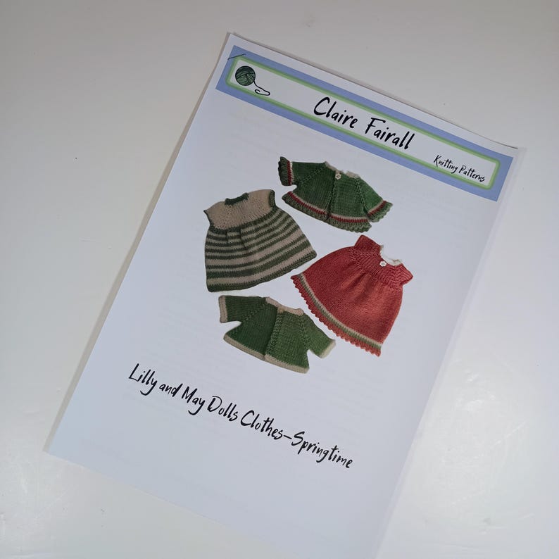 May include: A printed knitting pattern document titled Claire Fairall Knitting Patterns, featuring illustrations of four knitted doll garments: a striped dress, a red dress, and two green cardigans. The text reads Lilly and May Dolls Clothes-Springtime.