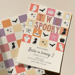 May include: Two rectangular birthday invitations featuring a checkered pattern in pink, orange, and purple. The cards display Halloween icons like ghosts, bats, spiders, and webs. Text reads: TWO SPOOKY, JOIN US TO CELEBRATE Bella is turning 2.