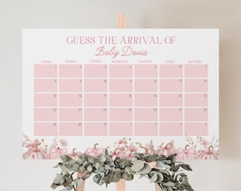 May include: A pink baby shower calendar with the text "Guess the Arrival of Baby Davis." The calendar grid is pink with dates. Floral and pumpkin illustrations decorate the bottom. The sign is displayed on a wooden easel.