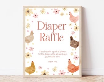 May include: A framed sign with the words "Diaper Raffle" in pink script, surrounded by watercolor chickens and flowers. The sign includes text that reads "If you brought a pack of diapers for the diaper raffle, please leave your tickets here. Thank You!"