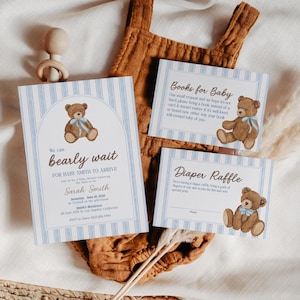 Può includere: Inviti e biglietti per baby shower a tema orsetto. L'invito recita "bearly wait" e include i dettagli dell'evento. Ulteriori biglietti richiedono libri e una riffa di pannolini. Il design presenta strisce blu e un orsetto marrone.