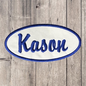 May include: White oval-shaped patch with a blue border. The name "Kason" is embroidered in blue cursive lettering.