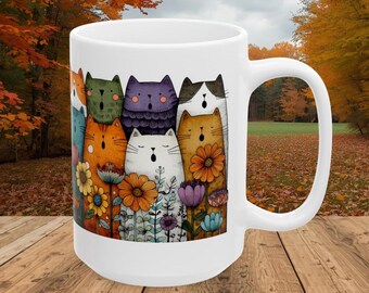 May include: White ceramic mug featuring a colorful illustration of singing cats and flowers. The cats are in various colors, including orange, green, and purple. The flowers include sunflowers and other blooms. The mug has a large handle.