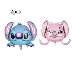 Może przedstawiać: Dwa balony foliowe w kształcie postaci Stitcha, jeden niebieski i jeden r&oacute;żowy. Niebieski balon ma duże czarne oczy i fioletowy nos. R&oacute;żowy balon mruga. Tekst "2 szt." znajduje się w lewym g&oacute;rnym rogu.