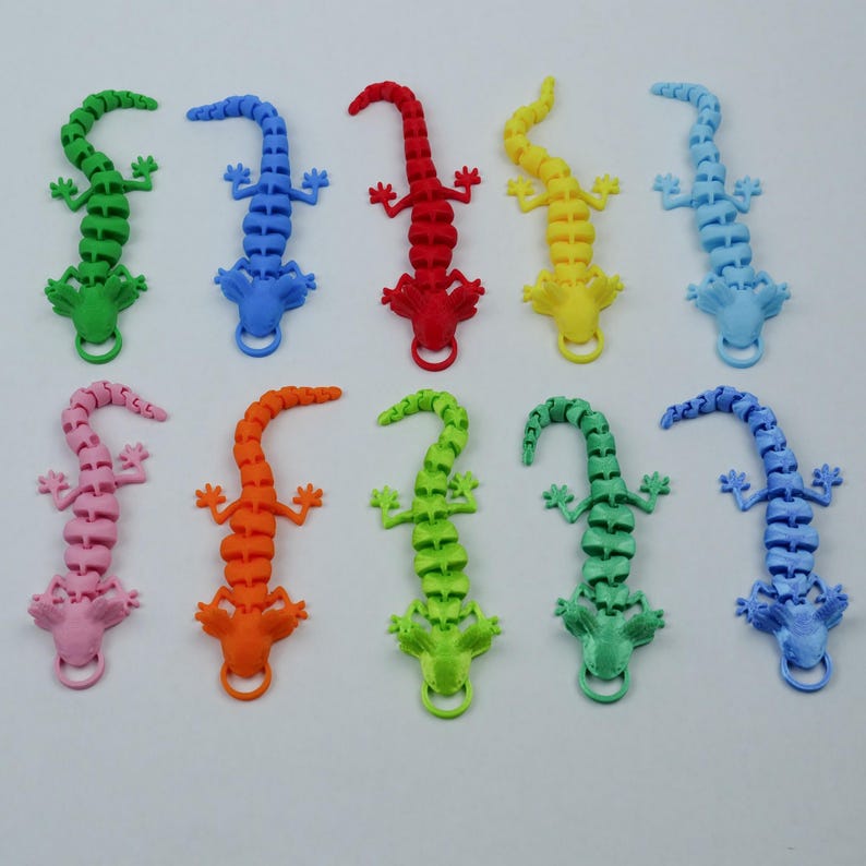May include: Ten colorful, segmented, plastic lizards. The lizards are in various colors, including blue, red, green, orange, pink, yellow, and light blue.