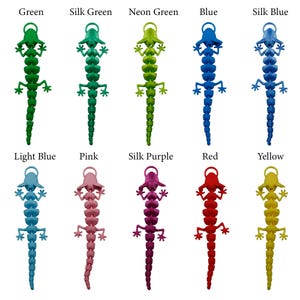 May include: Ten colorful lizard-shaped keychains in various colors, including green, blue, pink, purple, red, and yellow.