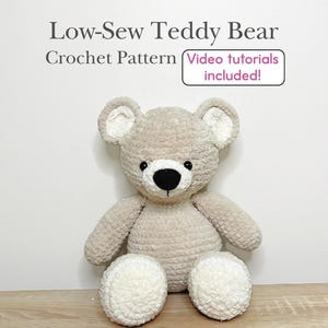 May include: A beige and white crocheted teddy bear with black eyes and a black nose. The text above reads Low-Sew Teddy Bear Crochet Pattern and Video tutorials included! The bear has a textured, plush appearance with round ears and feet.