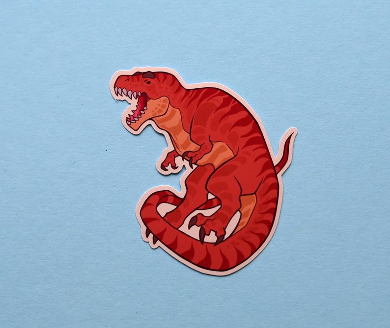 May include: Red dinosaur sticker with a curled tail and an open mouth. The dinosaur is outlined in black and has a white background.