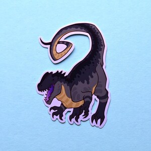 May include: A black and gray dinosaur sticker with a curled tail. The dinosaur has a purple tongue and yellow markings on its body.