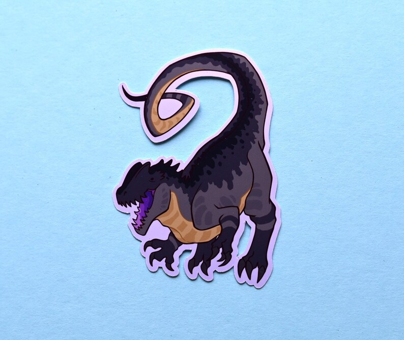 May include: A black and gray dinosaur sticker with a curled tail. The dinosaur has a purple tongue and yellow markings on its body.