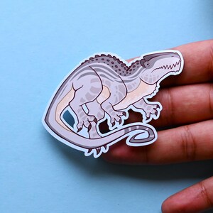 May include: A sticker of a cartoon dinosaur with a gray and white striped pattern. The dinosaur is in a running pose with its mouth open and its tongue sticking out.