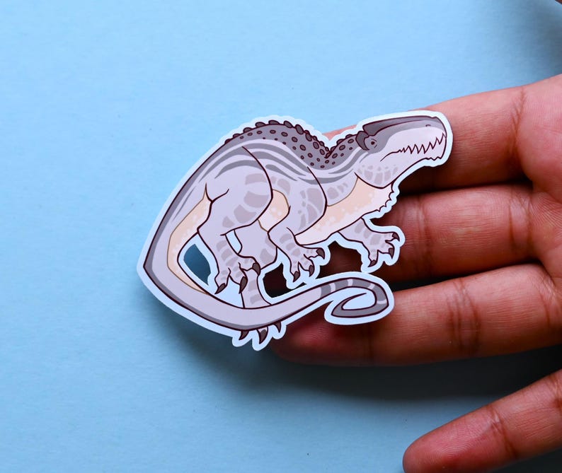 May include: A sticker of a cartoon dinosaur with a gray and white striped pattern. The dinosaur is in a running pose with its mouth open and its tongue sticking out.
