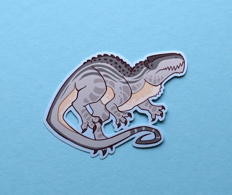May include: A gray and white dinosaur sticker with a striped pattern. The dinosaur has a long tail and a large head with sharp teeth.