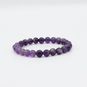 May include: A purple amethyst gemstone bracelet with round beads.