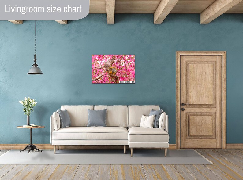 Puede incluir: Un sof&aacute; blanco con un lienzo de estampado floral colgado en la pared encima. El sof&aacute; est&aacute; en una habitaci&oacute;n con una puerta de madera y un techo de madera.
