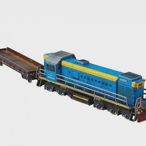 May include: A blue and yellow model train with a flatbed car. The train has a detailed design with visible windows and a red front. The flatbed car is brown. The train is set against a plain background.