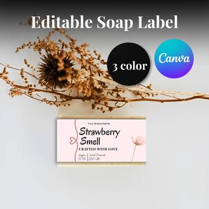 May include: A pink and white soap label with the text "Strawberry Smell" and "Crafted with Love". The label also includes the text "Vegan Cold Pressed" and "1.5 oz | 300 cm".