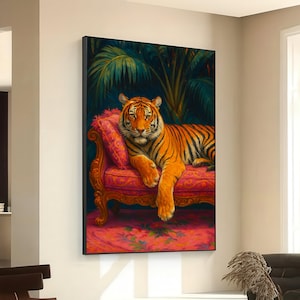 May include: A framed art print depicts a tiger lounging on a pink chaise lounge. The tiger has orange and black stripes and is set against a backdrop of lush green foliage. The chaise lounge has ornate gold trim.