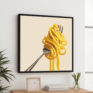 May include: A framed art print featuring a close-up of a fork holding a swirl of yellow spaghetti. The fork is silver, and the background is a light beige color. The artwork is displayed on a wooden surface.