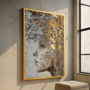 Puede incluir: Una obra de arte enmarcada que presenta el perfil de una mujer integrado con un diseño de árbol. La obra de arte tiene un marco dorado y una paleta de colores dorados, grises y blancos. El rostro de la mujer es sutilmente visible dentro del follaje del árbol.