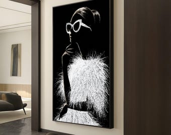 Puede incluir: Obra de arte en blanco y negro que representa a una mujer de perfil, con gafas de sol de gran tamaño y una prenda blanca y plumosa. La obra está enmarcada en negro y cuelga de una pared blanca en un interior moderno.