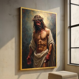Può includere: Un dipinto incorniciato raffigura un uomo con capelli lunghi, barba e una corona di spine. L'uomo è a torso nudo, avvolto in un panno bianco e ha sangue sul corpo. Il dipinto ha una cornice dorata ed è esposto su un muro.