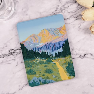 Puede incluir: Una ilustración digital de una cordillera con un camino sinuoso que conduce a través de un bosque. Las montañas están pintadas en tonos de amarillo, azul y morado, con un cielo azul arriba. El camino es de un amarillo brillante y el bosque es de un verde intenso.