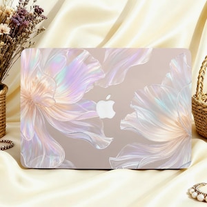 May include: A laptop hard shell case featuring a translucent, iridescent floral design with soft pastel hues and a pearlescent finish. The cover displays a clear cutout in the centre, revealing the silver Apple logo underneath the floral pattern.