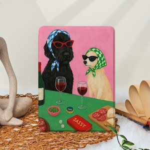 Peut inclure: Impression sur toile rectangulaire représentant deux chiens avec des lunettes de soleil et des foulards, dégustant du vin et des collations. Le fond est rose, la table verte. Le mot "SASSY" est sur une boîte rouge.
