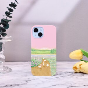 May include: A pink phone case with a scenic landscape and ducks walking on a path. The case has a camera lens cutout and a white background.