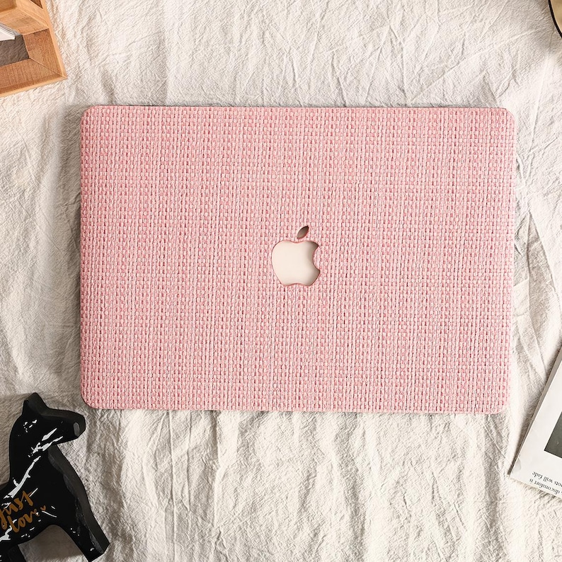 May include: A pink laptop case with a woven texture and a cut-out apple logo.