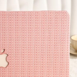 May include: A pink laptop case with a woven texture and a cut-out apple logo.