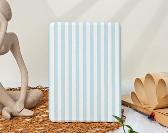 Puede incluir: Una funda rectangular para lector electrónico con un patrón de rayas verticales en azul claro y blanco. La funda tiene una superficie lisa y plana con esquinas redondeadas y un diseño uniforme que cubre toda la parte frontal del dispositivo.