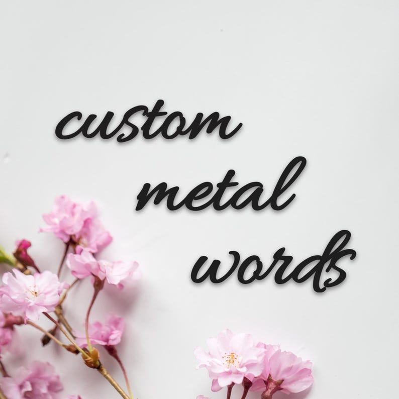 May include: Black metal words spell out "custom metal words" in a cursive font. Pink cherry blossoms are arranged at the bottom left and right corners of the image, set against a white background.