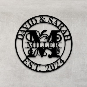 May include: Black metal circle with the text "David & Sarah Miller Est. 2024" and a stylised "M" in the centre.