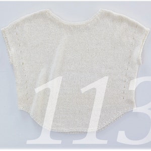 May include: A white crocheted top with a loose fit and short sleeves.