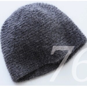 May include: A grey knitted beanie hat with a fuzzy texture.