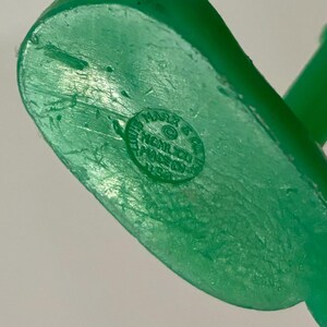 Pu&ograve; includere: Giocattolo di plastica verde con un timbro circolare sul fondo che recita "Louis Marx & Co.  Mech.  Made in U.S.A."