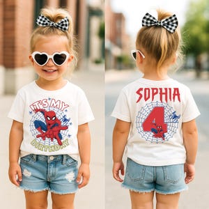 Op de afbeelding: Een wit T-shirt met een Spider-Man-afbeelding en de tekst "IT'S MY BIRTHDAY". De achterkant van het shirt heeft de naam "SOPHIA" en het nummer "4". Het kind draagt een spijkerbroekshort en hartvormige zonnebrillen.