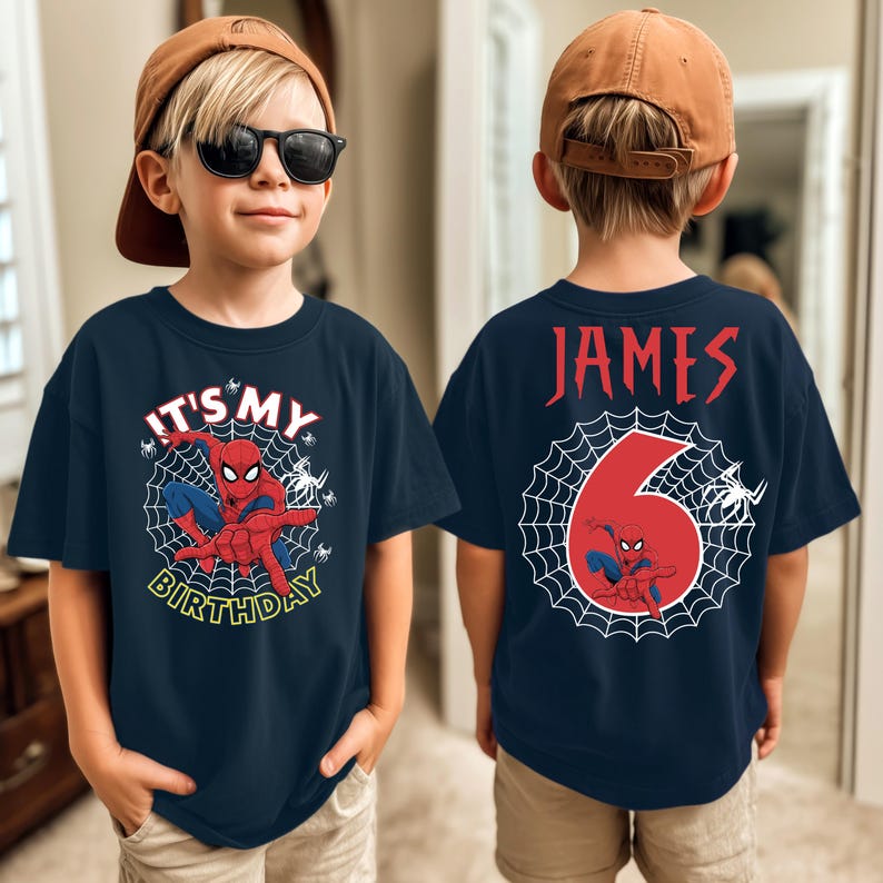 Op de afbeelding: Marineblauw T-shirt met een Spider-Man-afbeelding en de tekst "IT'S MY BIRTHDAY" op de voorkant. De achterkant van het shirt toont de naam "JAMES" en het nummer "6" met een Spider-Man-ontwerp.